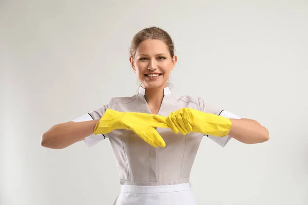 Portrait of beautiful female housekeeper wearing gloves on white background — Stock Photo, Image