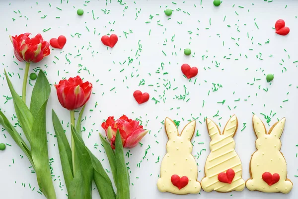 Composition avec biscuits de Pâques et tulipes sur fond blanc — Photo