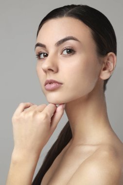 Gri arka plan üzerinde sağlıklı cilt ile güzel bir kadın portresi