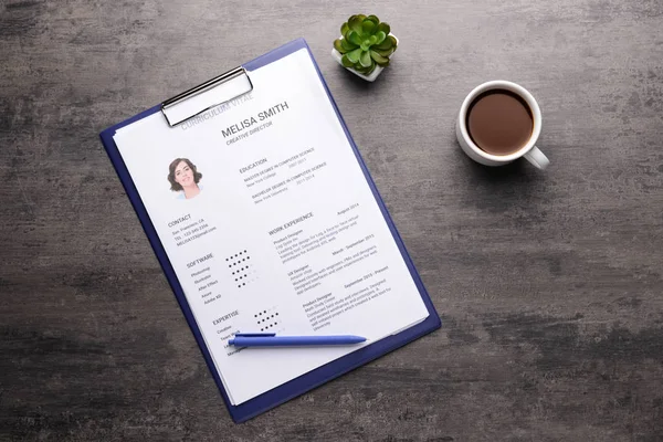 Job resume with cup of coffee on grey table