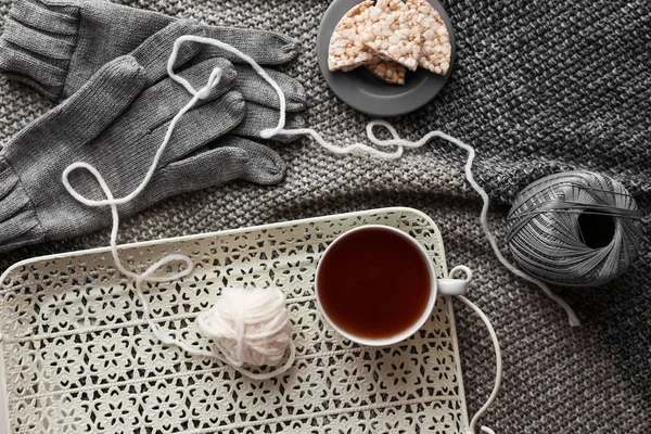 Bandeja con taza de té caliente, hilos y pan crujiente a cuadros —  Fotos de Stock