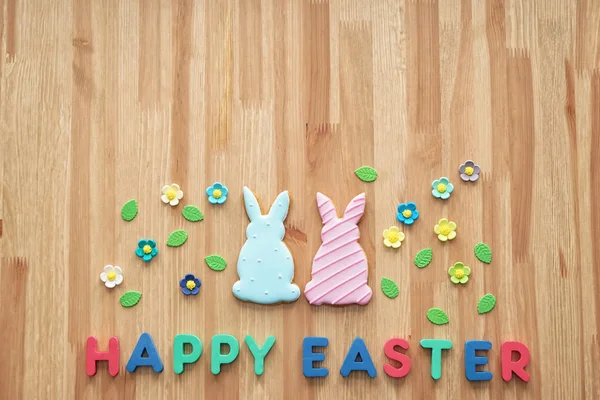 Tasty cookies with text HAPPY EASTER on wooden table — Stock Photo, Image