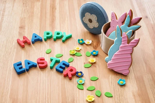 Tasty cookies with text HAPPY EASTER on wooden table — Stock Photo, Image