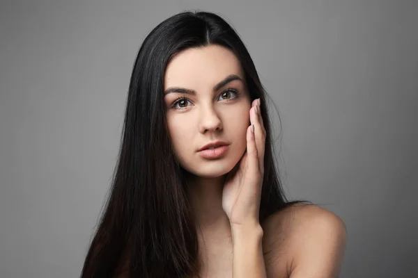 Portrait of beautiful woman with healthy skin on grey background — Stock Photo, Image