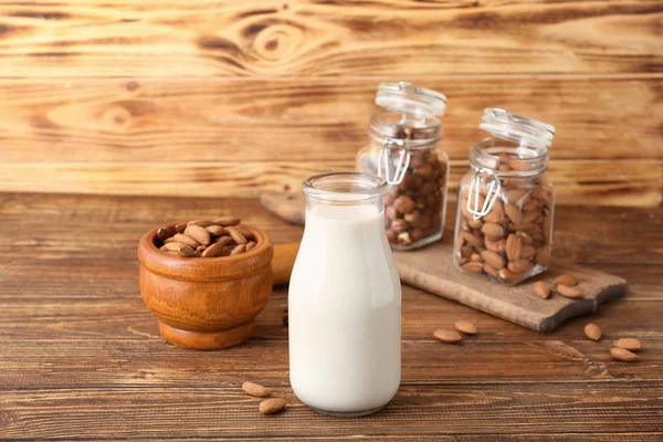 Bottle of tasty nut milk on wooden table — Stock Photo, Image