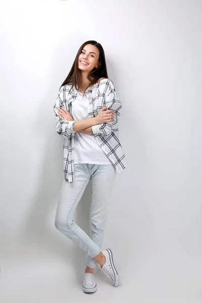 Portrait of beautiful woman in casual clothes on light background — Stock Photo, Image
