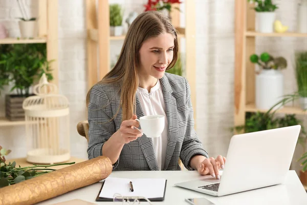 Beautiful female florist working at table in shop — Stock Photo, Image