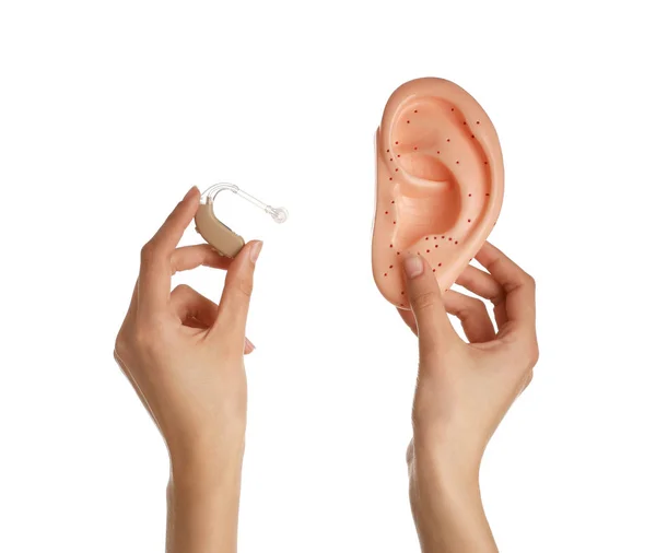 Female hands with hearing aid and model of ear on white background — Stock Photo, Image