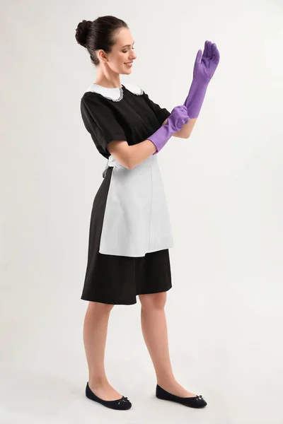 Portrait of beautiful female housekeeper wearing gloves on white background — Stock Photo, Image
