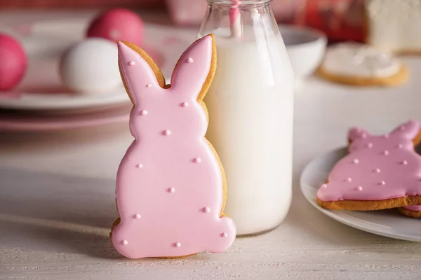 Gustoso biscotto pasquale con bottiglia di latte sul tavolo bianco — Foto Stock