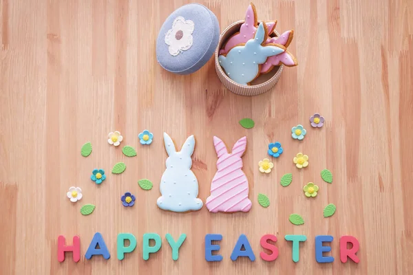 Tasty cookies with text HAPPY EASTER on wooden table — Stock Photo, Image
