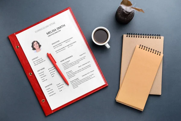 Job resume with notebooks and cup of coffee on grey background