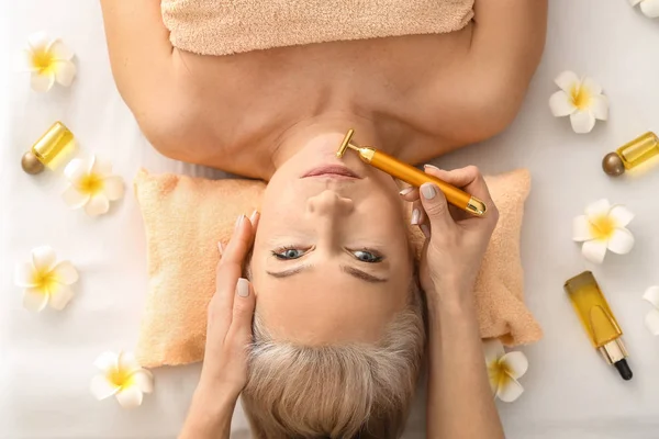 Mature woman receiving face massage in beauty salon — Stock Photo, Image