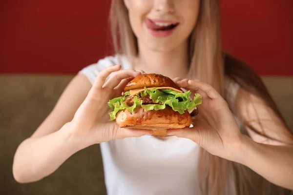 Beautiful young woman with tasty burger, closeup — Stock Photo, Image