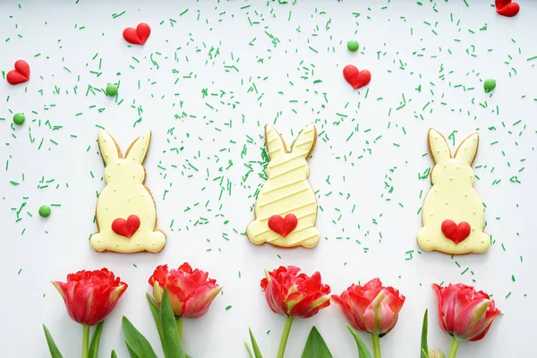 Komposition mit Osterkeksen und Tulpen auf weißem Hintergrund — Stockfoto