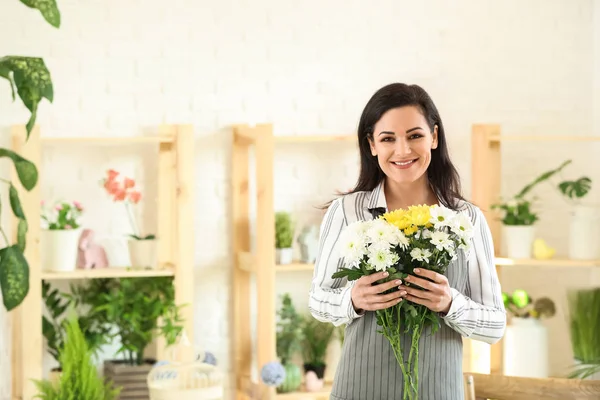 Linda florista feminina com buquê de flores na loja — Fotografia de Stock