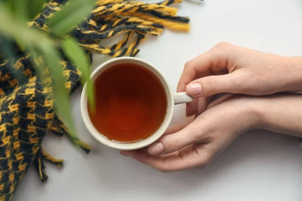 Female hands with cup of hot tea on light background — Stock Photo, Image