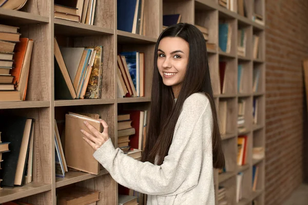 Πορτρέτο του όμορφη νεαρή γυναίκα κοντά βιβλιοθήκη στη βιβλιοθήκη — Φωτογραφία Αρχείου