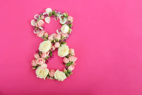 Figure 8 made of fresh flowers on color background — Stock Photo, Image