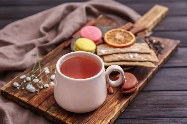 Kopje warme thee met zoetigheden op houten tafel — Stockfoto