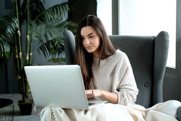 Beautiful young woman using laptop at home — Stock Photo, Image