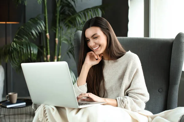 Bella giovane donna che utilizza il computer portatile a casa — Foto Stock