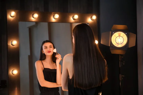 Portrait de belle jeune femme appliquant le maquillage près du miroir — Photo