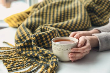 Evde sıcak çay içen bir kadın, yakın plan.