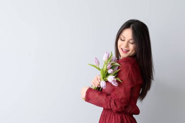 Buket çiçek ışık arka plan üzerinde olan kadın. 8 Mart kutlama