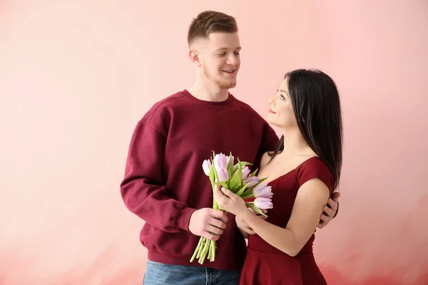 Joven saludando a su esposa con 8 Marzo sobre fondo de color —  Fotos de Stock