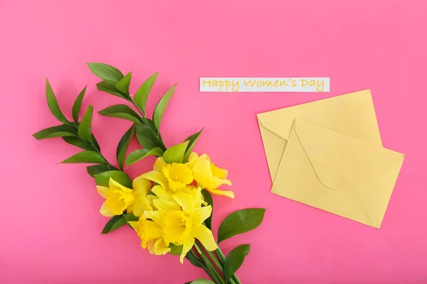 Kuvert med vackra blommor för internationella kvinnodagen på färgbakgrund — Stockfoto