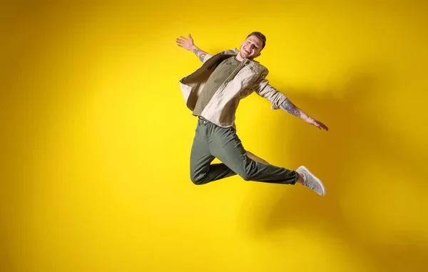 Handsome jumping man against color background — Stock Photo, Image