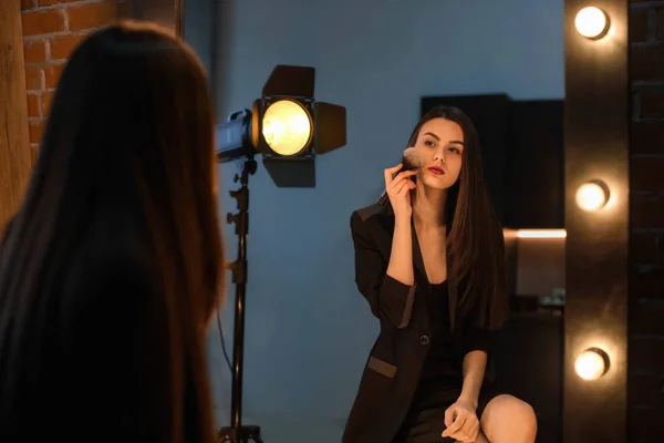 Portrait de belle jeune femme appliquant le maquillage près du miroir — Photo