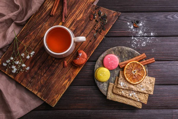 Kopje warme thee met zoetigheden op houten tafel — Stockfoto