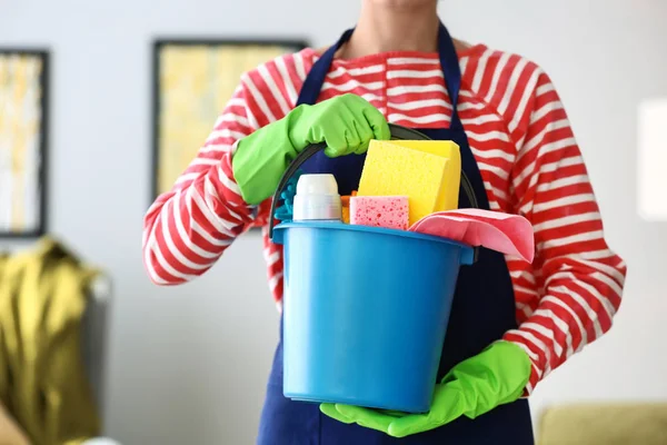 Beautiful woman with cleaning supplies at home — Stock Photo, Image