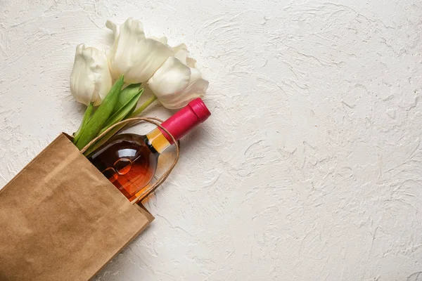 Τσάντα με μπουκάλι κρασί και λουλούδια σε λευκό φόντο — Φωτογραφία Αρχείου