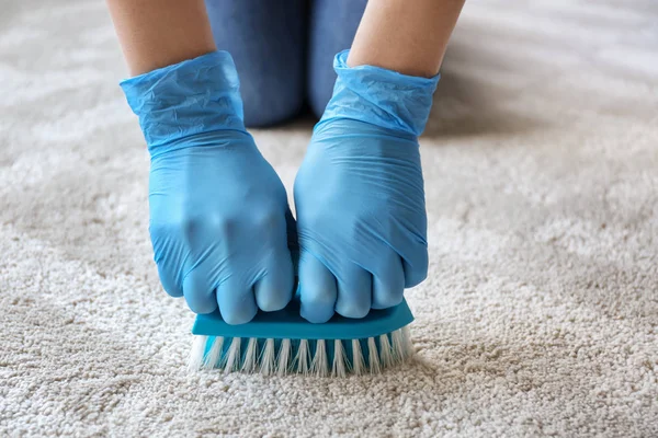 Жінка прибирає килим вдома — стокове фото