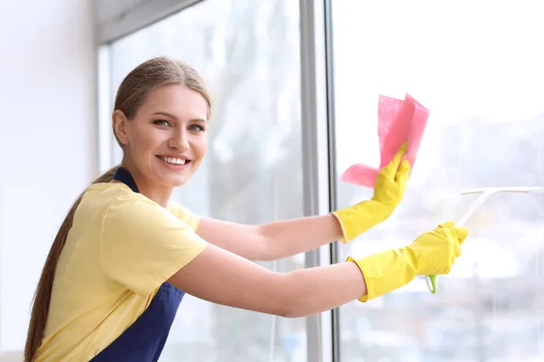 Mooie vrouw schoonmaken raam thuis — Stockfoto