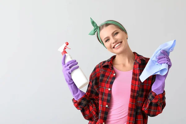 Retrato de mulher bonita com suprimentos de limpeza em fundo claro — Fotografia de Stock