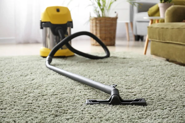 Vacuum cleaner on soft carpet in room — Stock Photo, Image