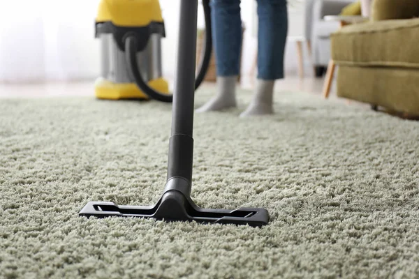 Frau putzt Teppich zu Hause mit Staubsauger — Stockfoto