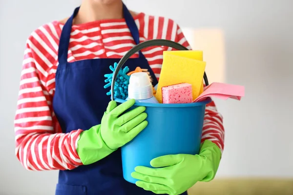 Beautiful woman with cleaning supplies at home — Stock Photo, Image