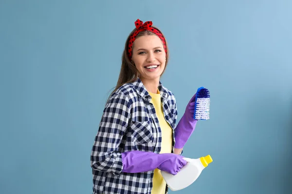 Portret van mooie vrouw met schoonmaak leveringen op kleur achtergrond — Stockfoto