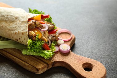 Tasty doner kebab on wooden board clipart