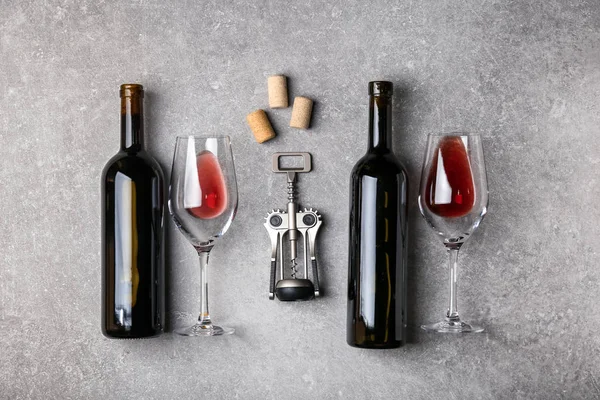 Composition with bottles of red wine and glasses on grey background — Stock Photo, Image