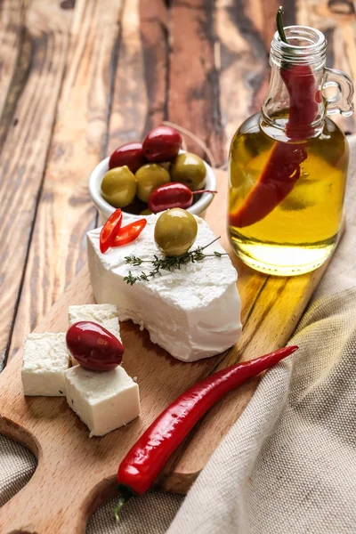 Lezzetli peynir ve zeytin yağı ahşap masa üzerinde kurulu