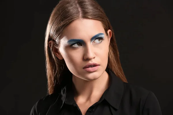 Hermosa joven con maquillaje brillante sobre fondo oscuro — Foto de Stock