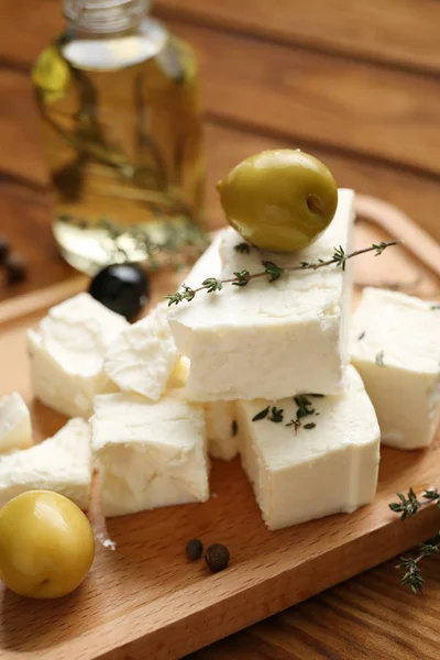 Prato com queijo feta saboroso e azeitonas na mesa de madeira, close-up — Fotografia de Stock