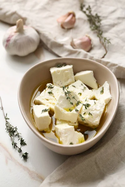 Plate with tasty feta cheese, thyme and olive oil on light background — Stock Photo, Image