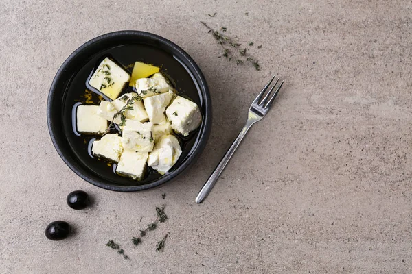 Plate with tasty feta cheese, thyme and olive oil on grey table — Stock Photo, Image